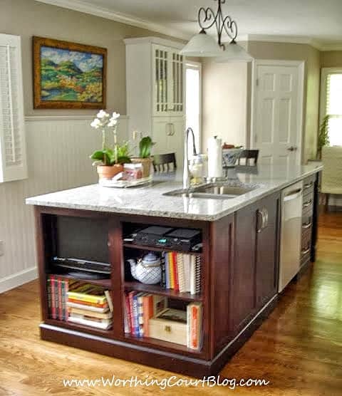 A dark wood kitchen island contrasts nicely with the white cabinets in this remodeled kitchen.