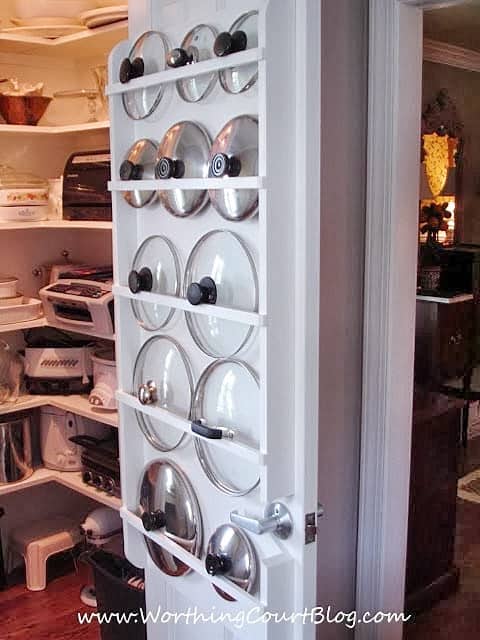 A diy pot lid holder on a door in the kitchen