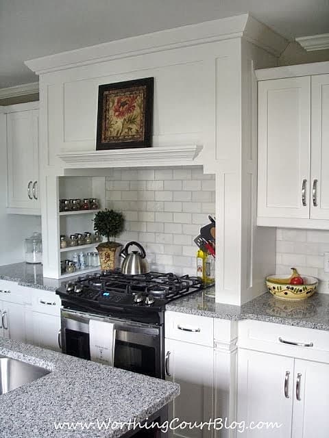 Custom kitchen range hood with spice shelves built into the sides