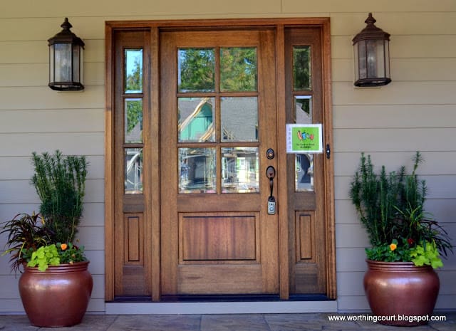 front door with sidelights, oversized exterior lights and filled containers via Worthing Court blog