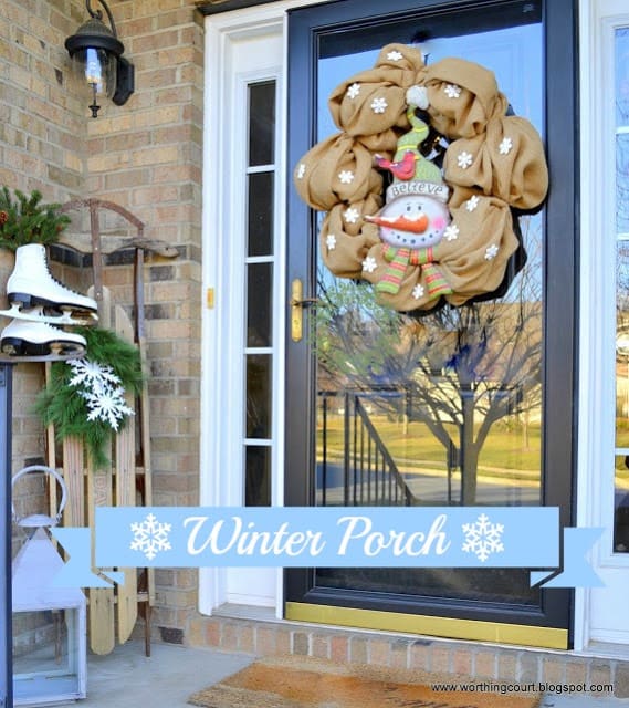 Winter front porch with a snowman wreath, vintage sled and vintage ice skates via Worthing Court blog
