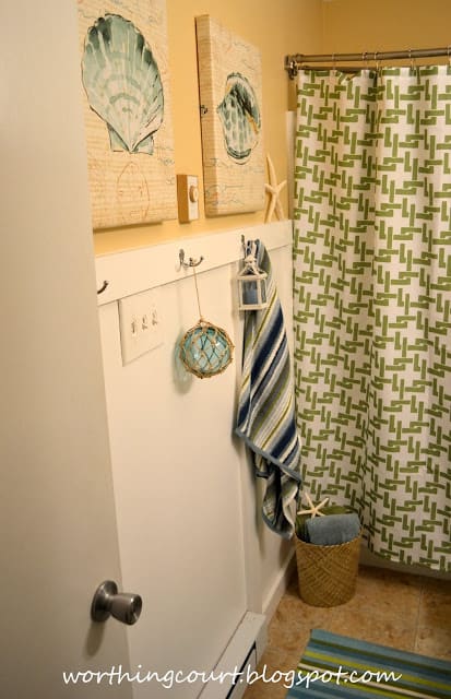 A bathroom with seashell pictures on the wall and beachy inspired decor.