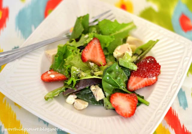 The salad on a plate with a fork beside it.