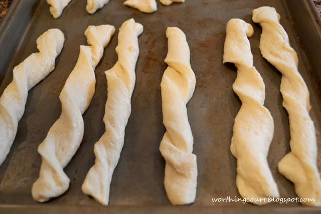 The breadsticks on a baking sheet ready to go into the oven.