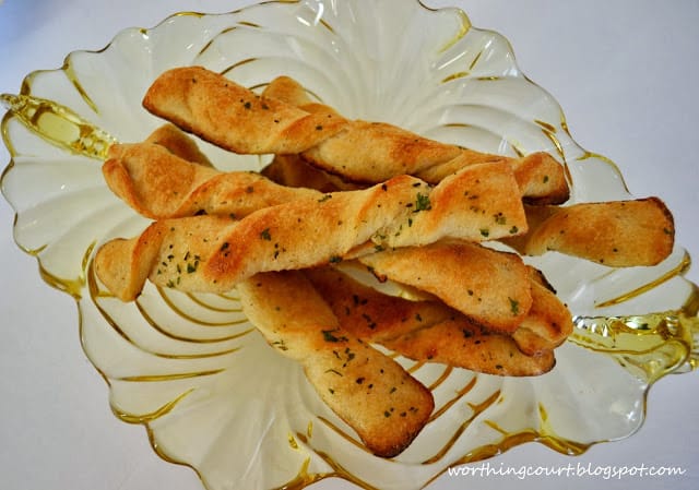 The baked breadsticks on a glass plate.