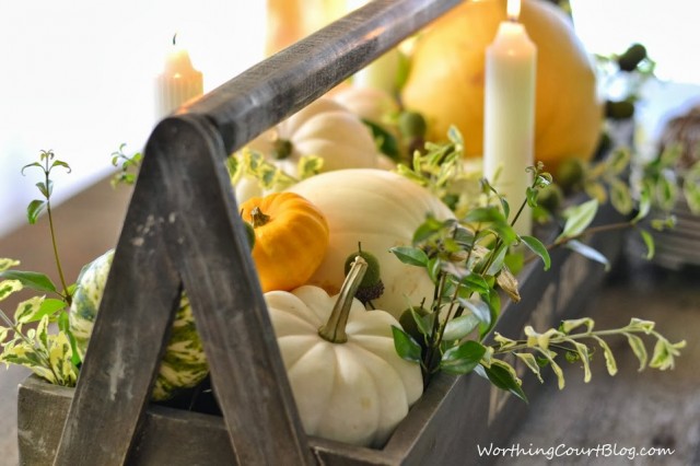 Worthing Court: Wooden tool box filled with yellow and white pumpkins and fresh greenery. The aged wood makes a great base for the centerpiece.