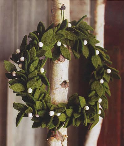 A green leaf felt wreath with white berries.