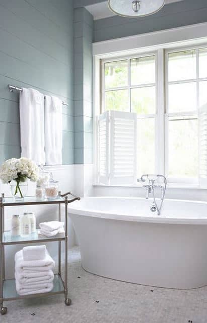 A bar cart in the bathroom is a stylish way to organize fluffy towels and bathroom essentials