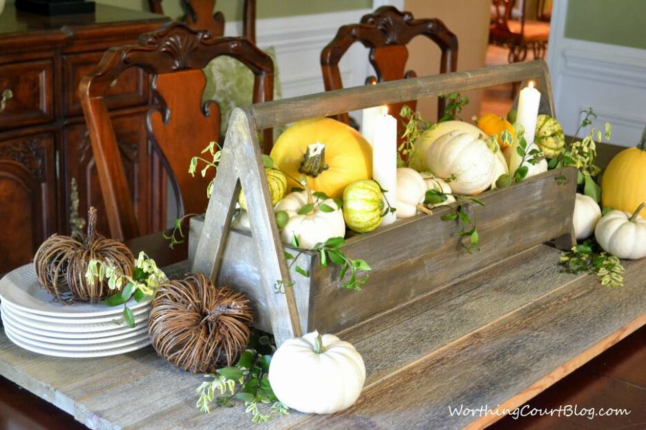 Fall centerpiece using live greenery and pumpkins in a wooden box.