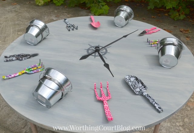 round table top with buckets and garden tools used to make a huge diy clock