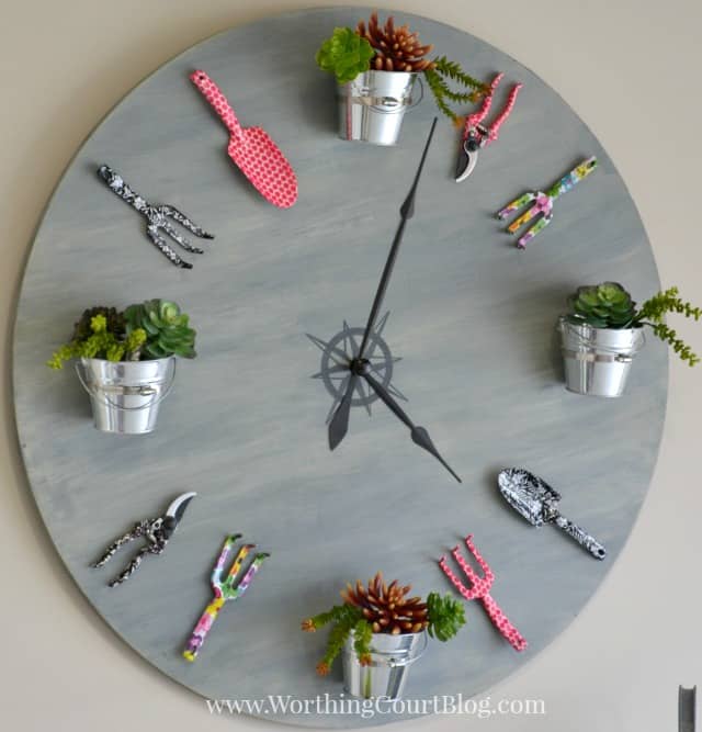 huge diy wall clock with buckets and garden tools attached to the face