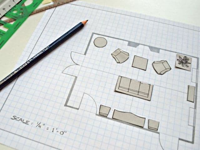 Using small pieces of cardboard cut out in the size of furniture pieces to help plan a furniture arrangement