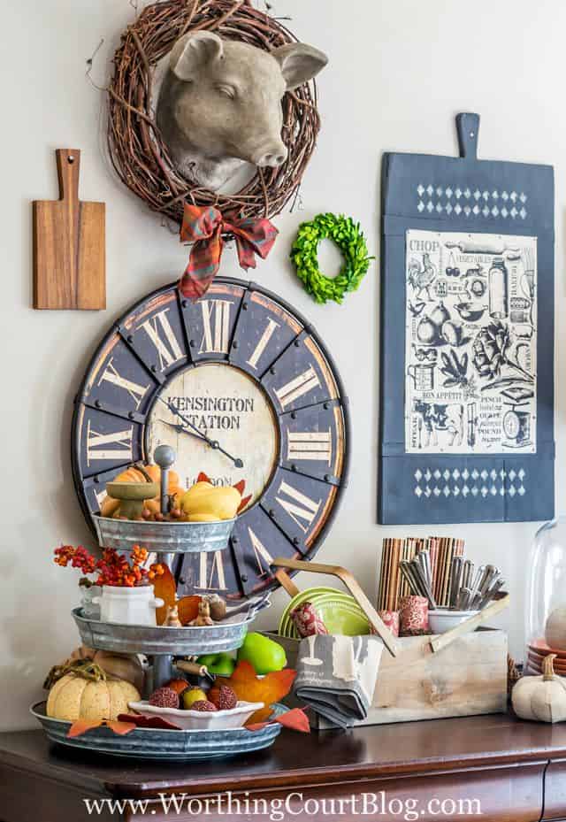 A ceramic pigs head on the wall with a grapevine wreath around it.