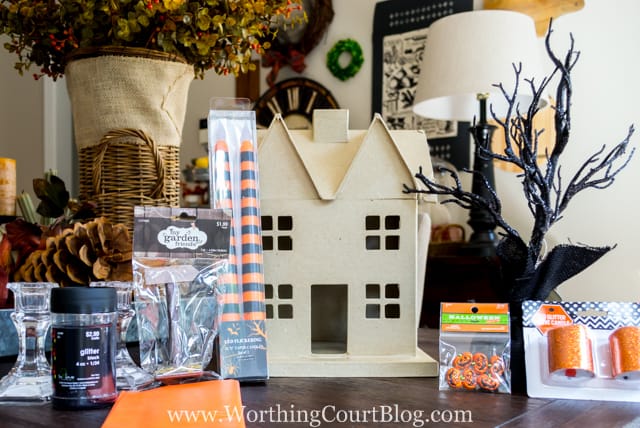 The cardboard house, and all the accessories to make it Halloween on the table.