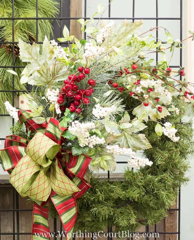 Red berries, white berries, a large bow and holiday leaves decorate the wreath.