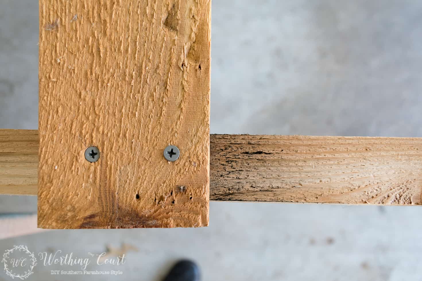 Nailing the pieces of wood together to form the ladder.