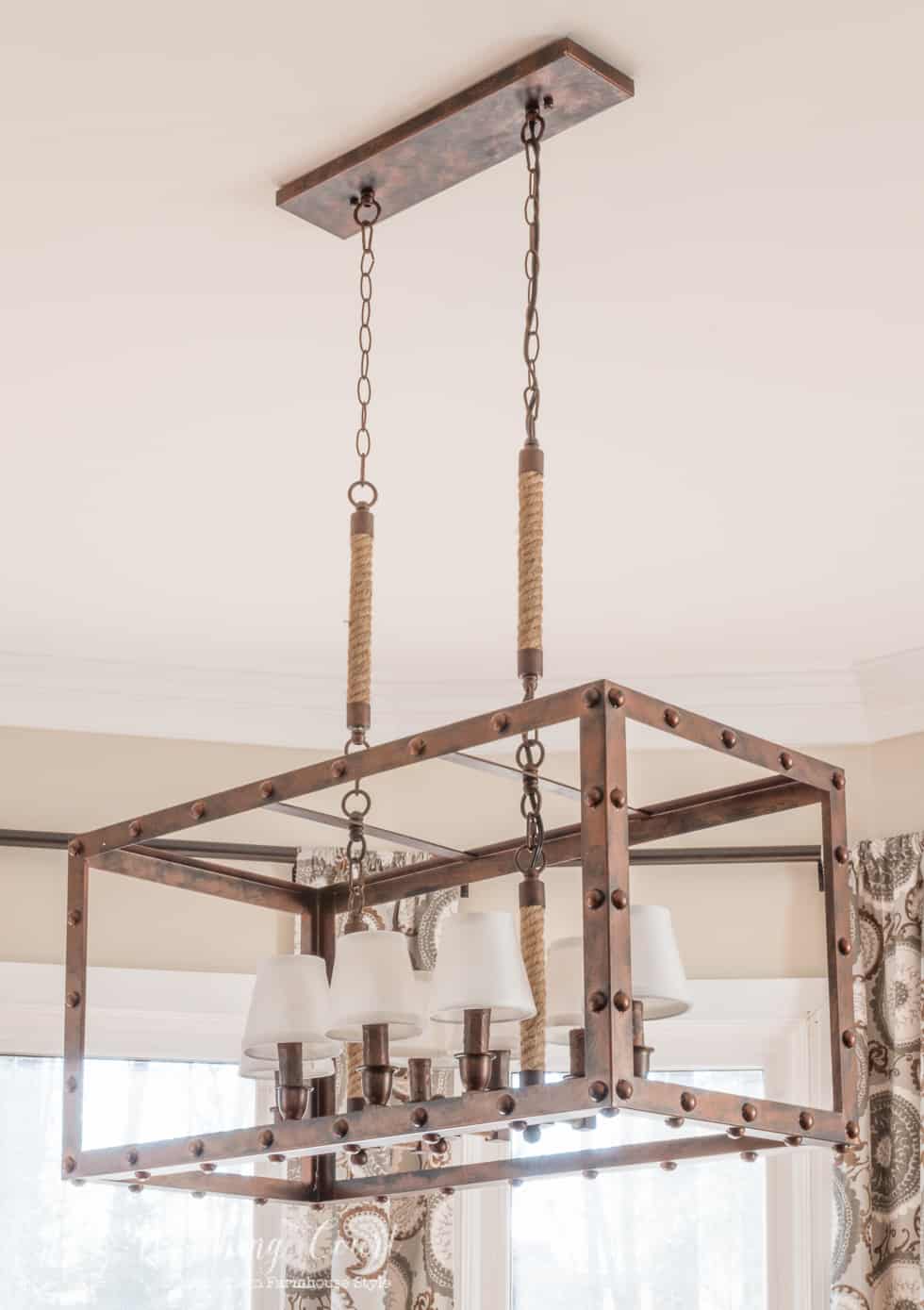 Rustic industrial light fixture in a farmhouse style kitchen breakfast area