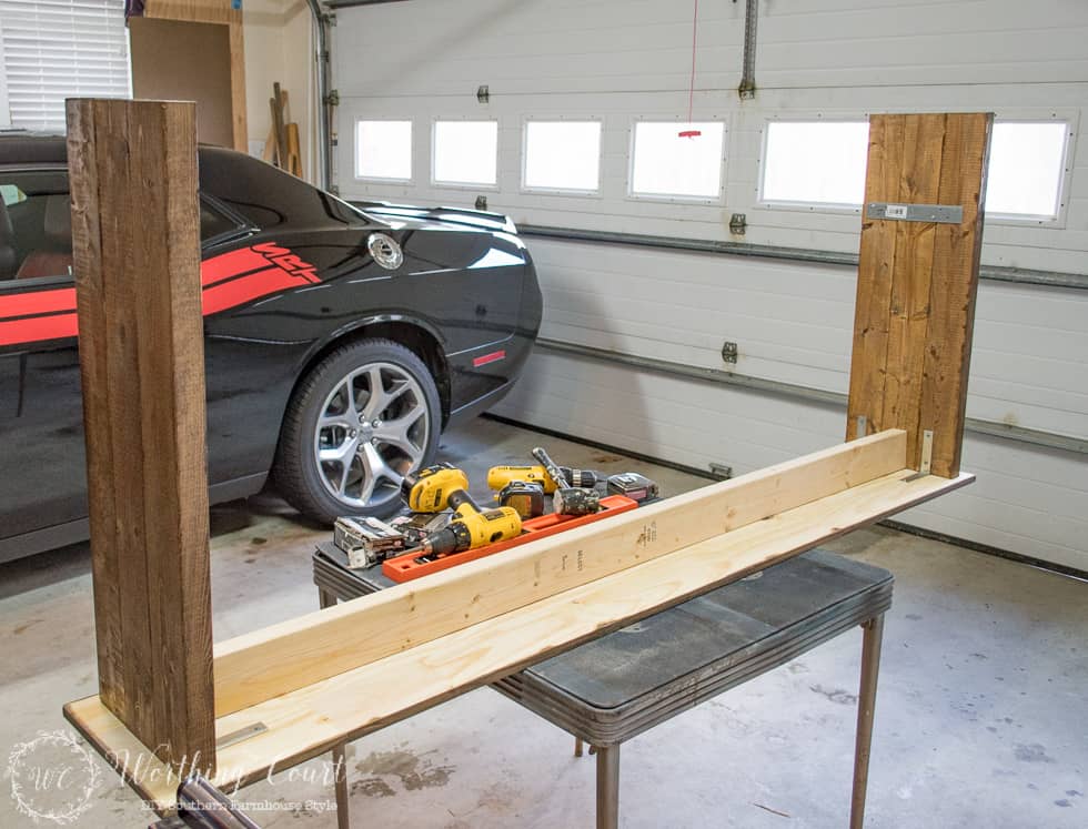 Building the farmhouse table in the garage with a car beside it.