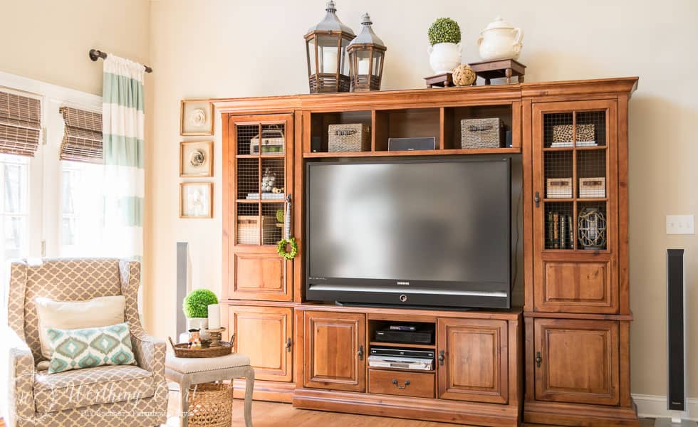 The before and after of this family room is amazing. It was taken from dark and dated to light and bright filled with rustic farmhouse touches, which includes a rustic entertainment center.
