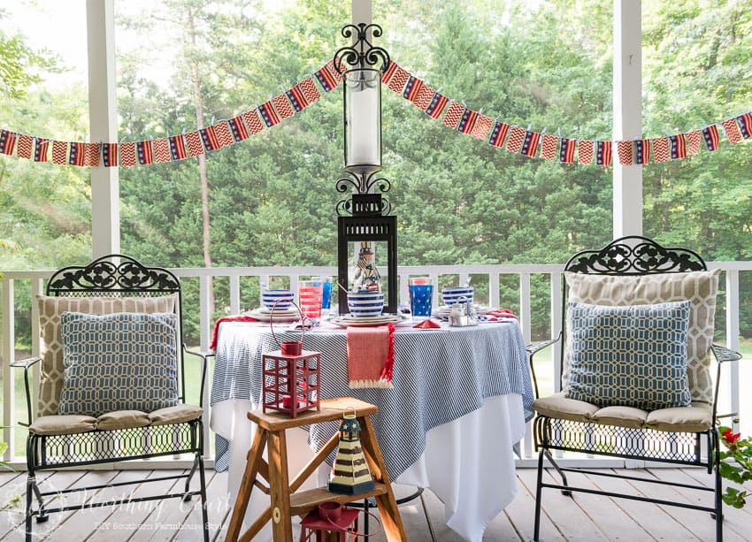 A patriotic table setting on a farmhouse porch filled with loads of red, white and blue vintage Americana patriotic decorating ideas for Memorial Day, Flag Day and July 4th.