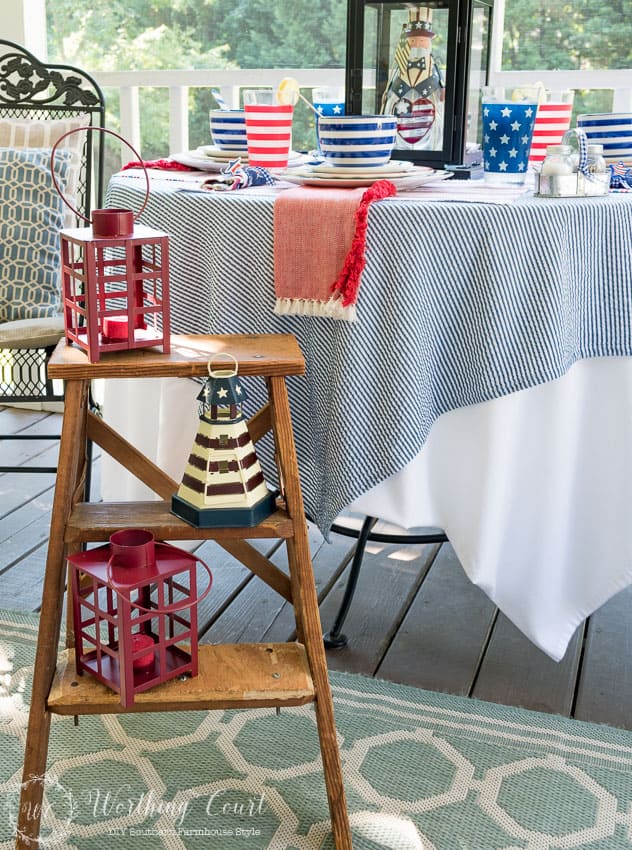 A farmhouse porch filled with loads of red, white and blue vintage Americana patriotic decorating ideas for Memorial Day, Flag Day and July 4th.