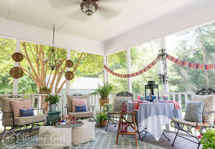 A farmhouse porch filled with loads of red, white and blue vintage Americana patriotic decorating ideas for Memorial Day, Flag Day and July 4th.
