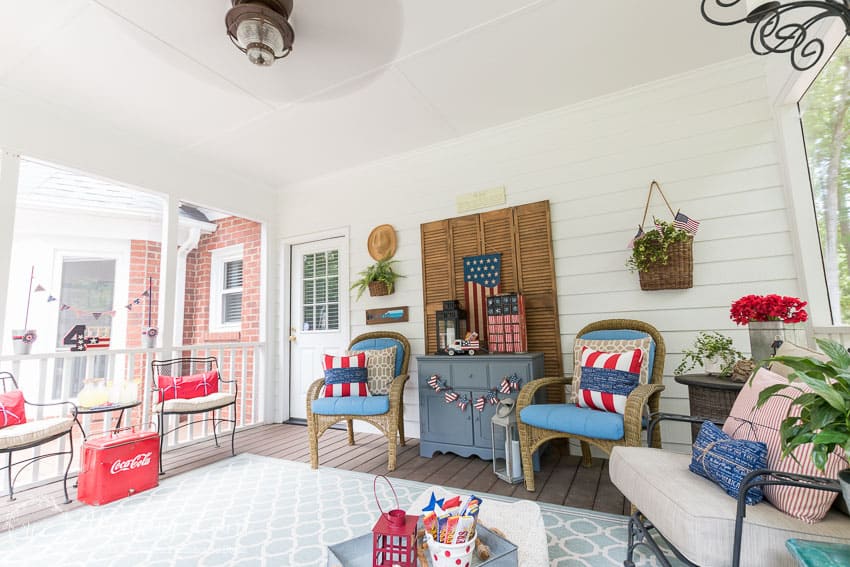 A farmhouse porch filled with loads of red, white and blue vintage Americana patriotic decorating ideas for Memorial Day, Flag Day and July 4th.