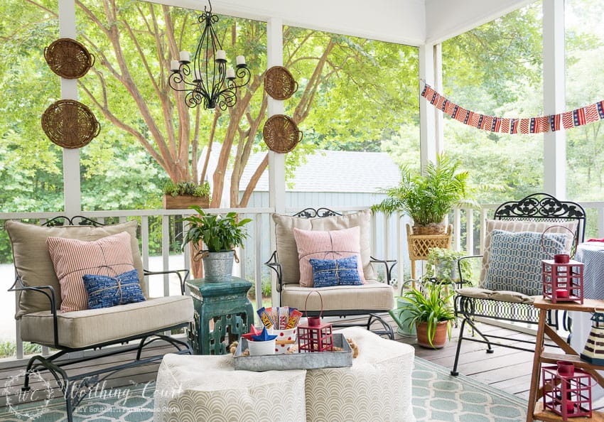 A farmhouse porch filled with loads of red, white and blue vintage Americana patriotic decorating ideas for Memorial Day, Flag Day and July 4th.