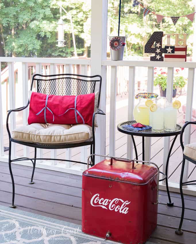 A farmhouse porch filled with loads of red, white and blue vintage Americana patriotic decorating ideas for Memorial Day, Flag Day and July 4th.