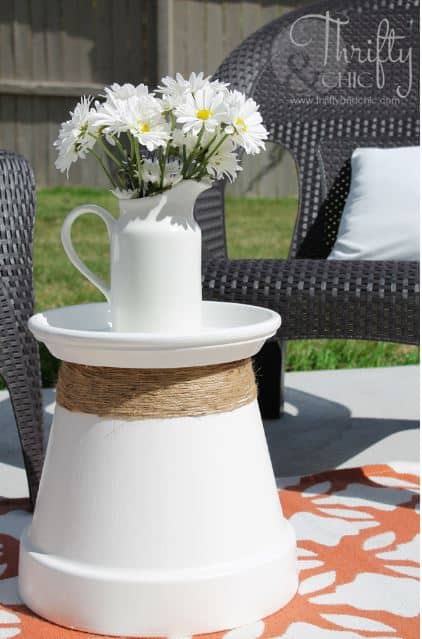 Dress up a large terra cotta pot and its drainage tray with some spray paint and twine for an inexpensive outdoor table.