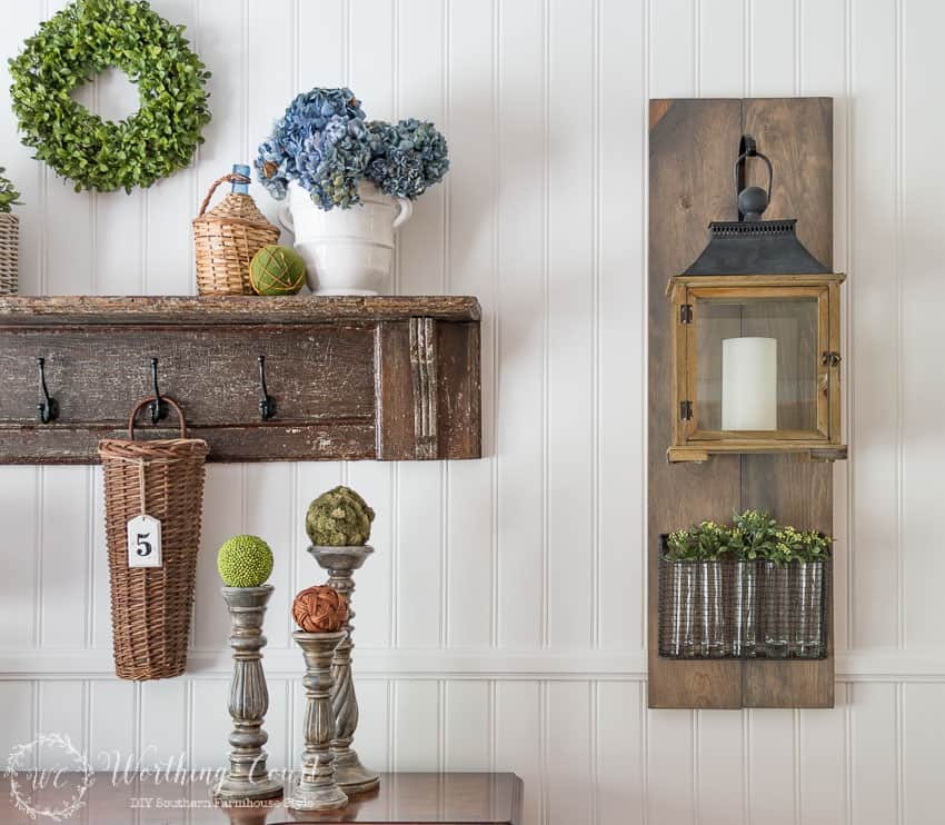 DIY farmhouse style hanging lantern and wire basket filled with vases and sprigs of greenery