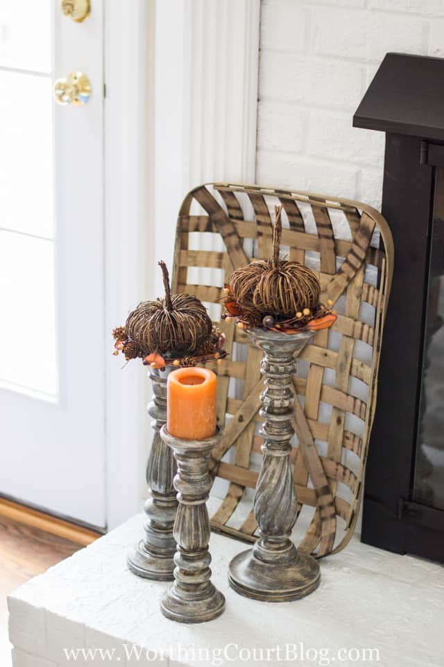 Top various height candlesticks with pumpkins and a candle for an easy fall display.