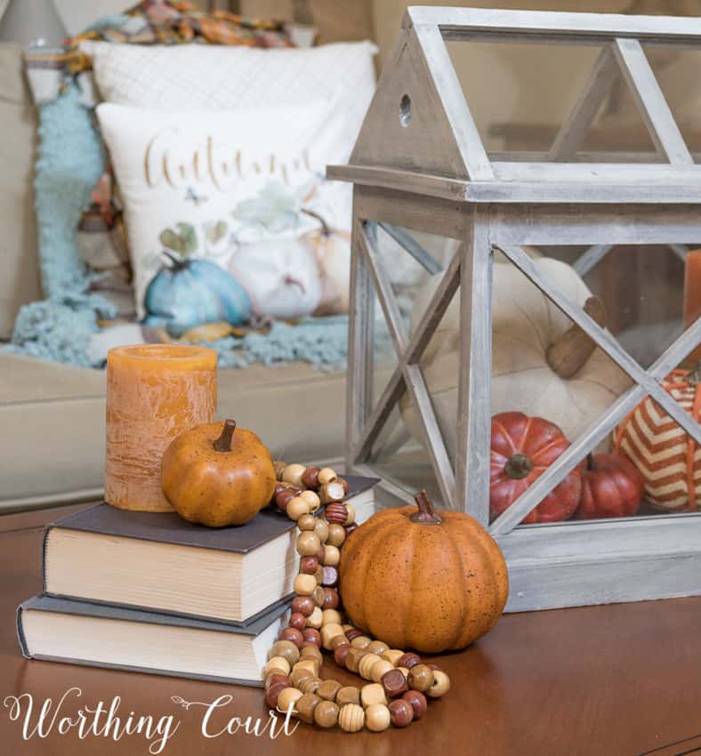 Fall coffee table with a terrarium, stacked books, bead strands and pumpkins || Worthing Court