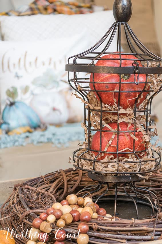 Fill a metal cage with pumpkins and brown paper filler for an easy fall display