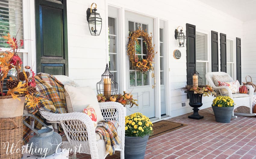 Farmhouse style fall front porch with wicker rockers and fall urns || Worthing Court