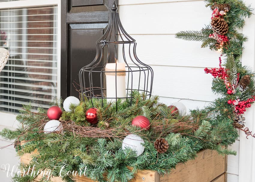 DIY wood planters filled with Christmas greenery and lanterns.