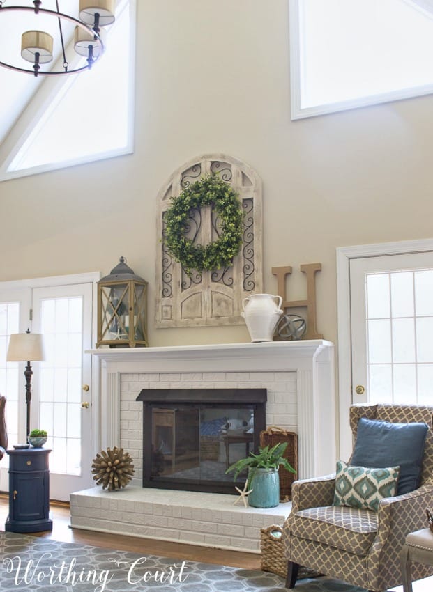 Farmhouse style white painted brick fireplace and mantel decorated for spring || Worthing Court
