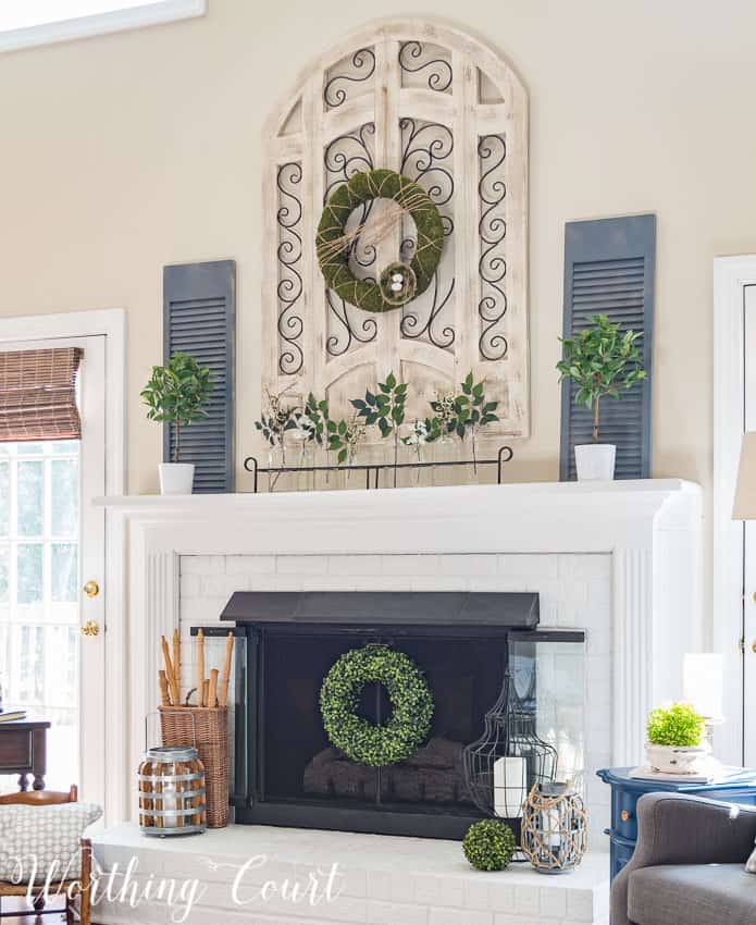 A fresh and easy farmhouse style spring fireplace with faux greenery, glass bottles and black metal accents|| Worthing Court