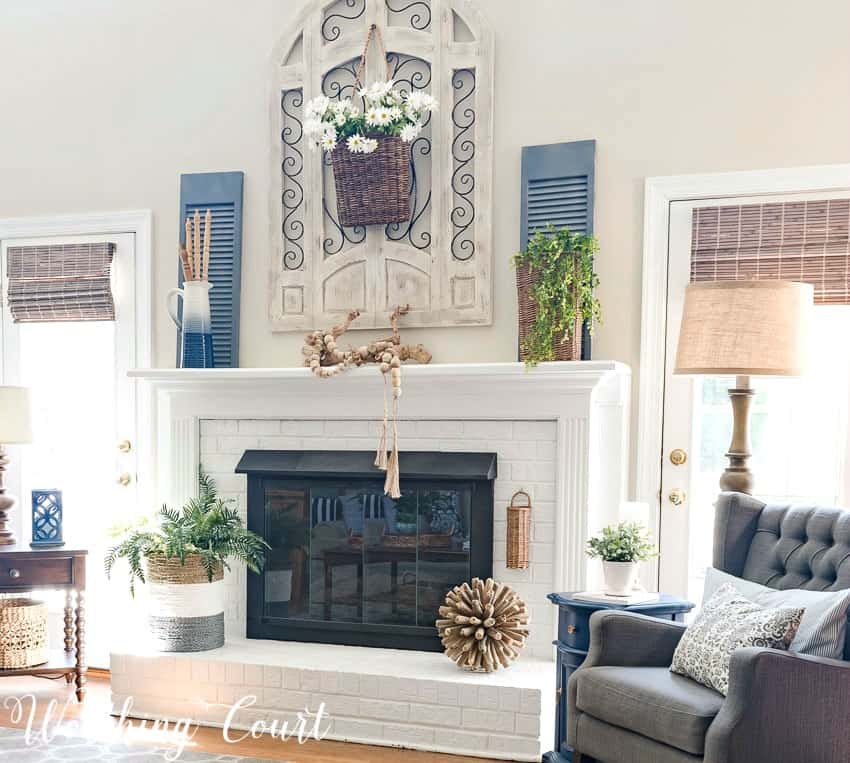 Painted red brick fireplace decorated for summer with simple organic elements || Worthing Court