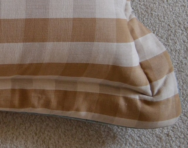 corner of a brown and beige pillow sham