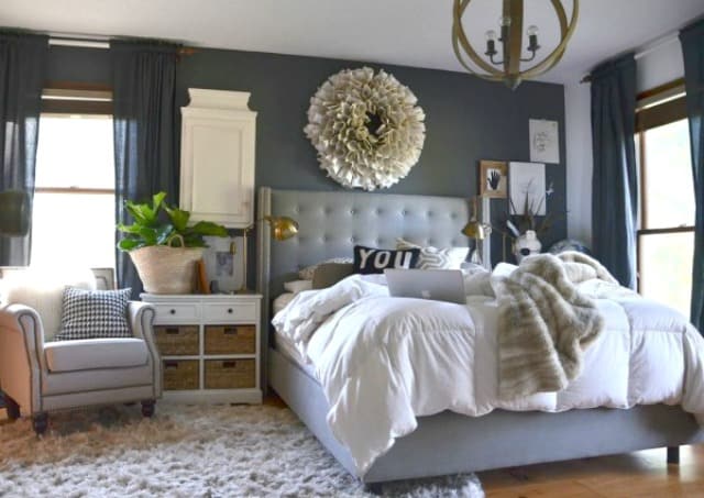 A blue/grey room with a small area rug.