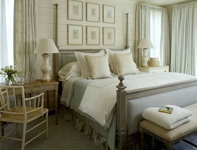 There is two rows of pictures behind the bed all in neutral tones.