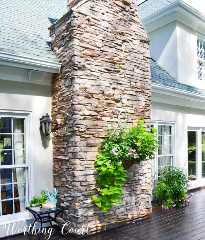 Outdoor planter hanging from rock chimney.