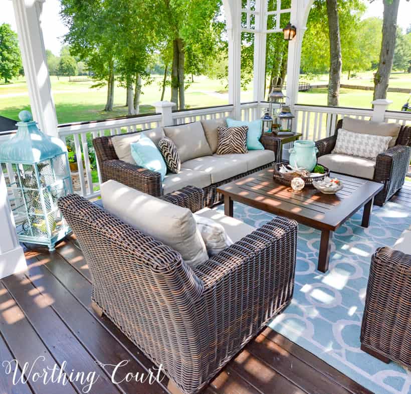 The back deck with furniture and a blue and white area rug.