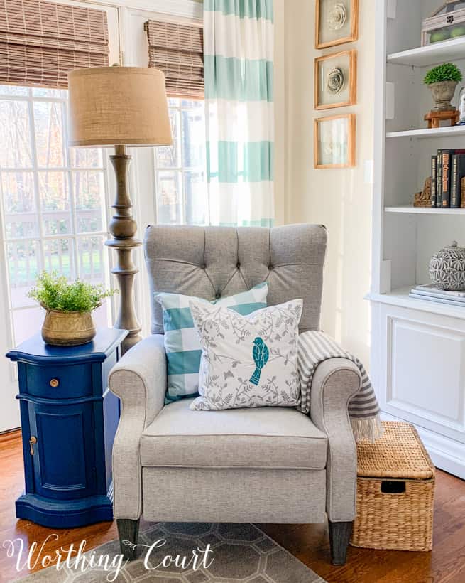 gray chair with blue and white throw pillows