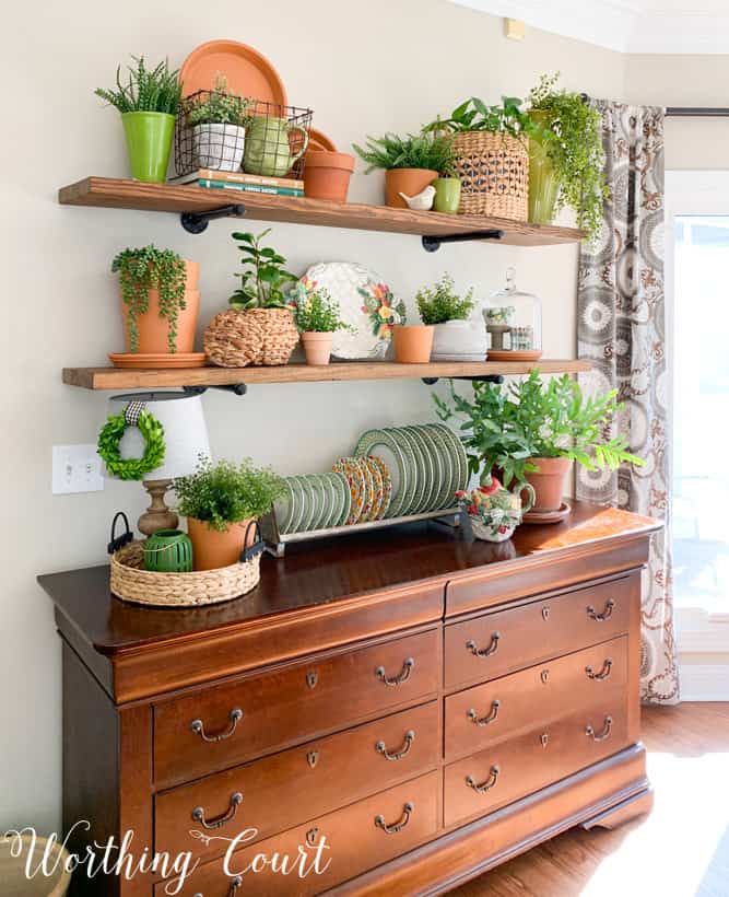 open shelves decorated for spring with terra cotta pots and greenery