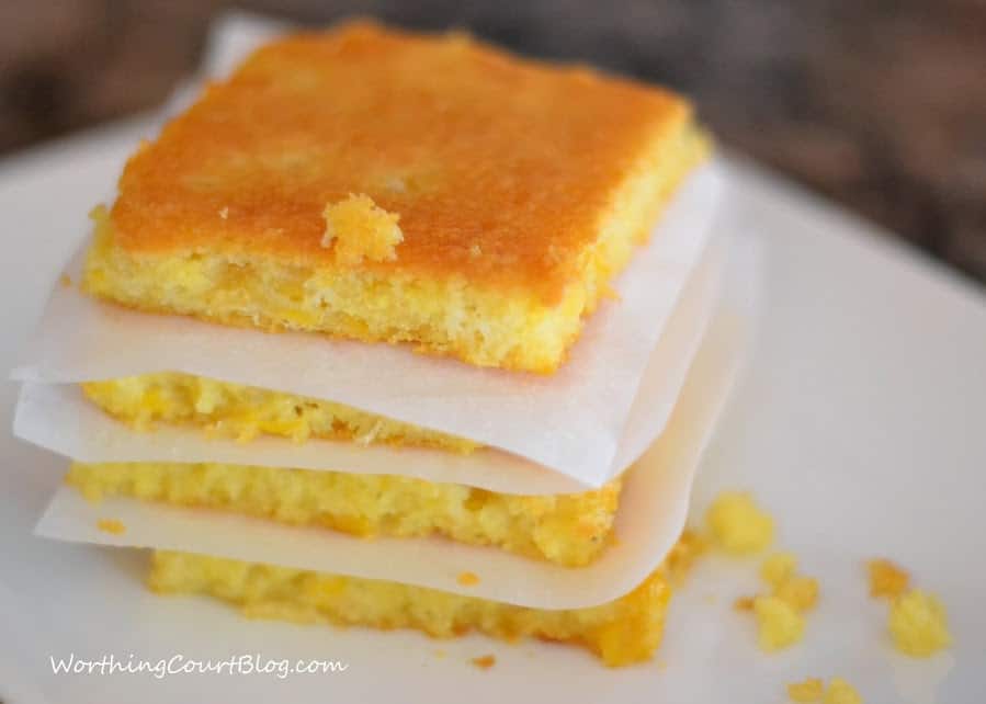 Sweet, Moist and Delicious Cornbread stacked up with parchment between the slices.