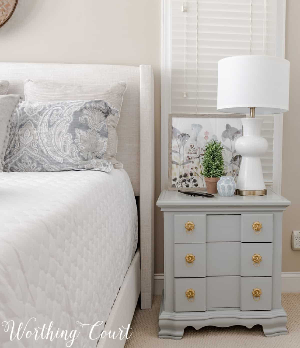 gray night stand with white lamp beside bed
