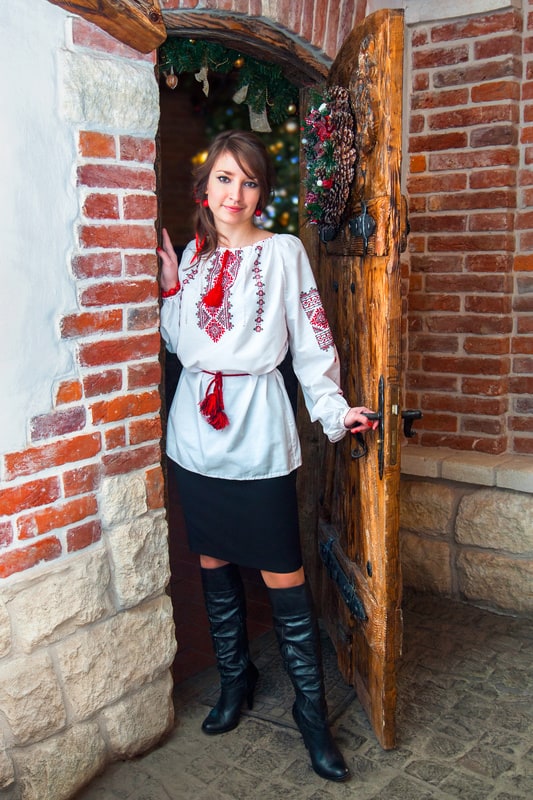 woman in white shirt black skirt opening wood door