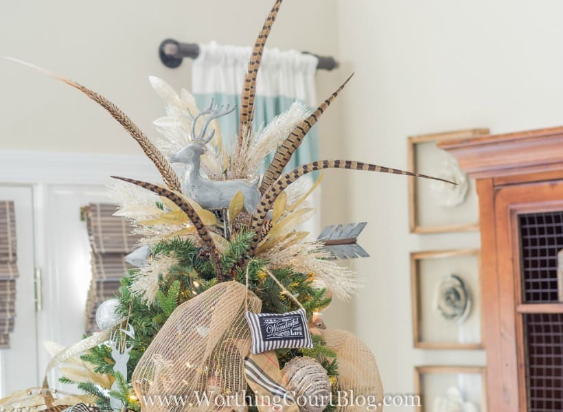 Christmas tree topper with a reindeer and feathers.